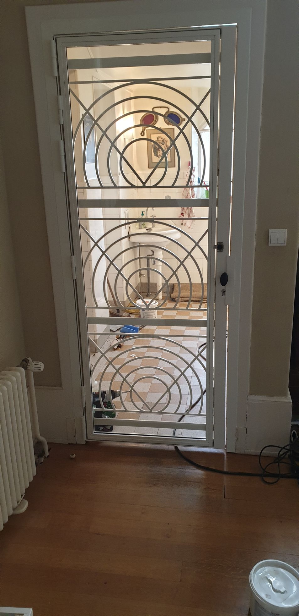 Porte métallique intérieure décorative, avec des motifs géométriques.