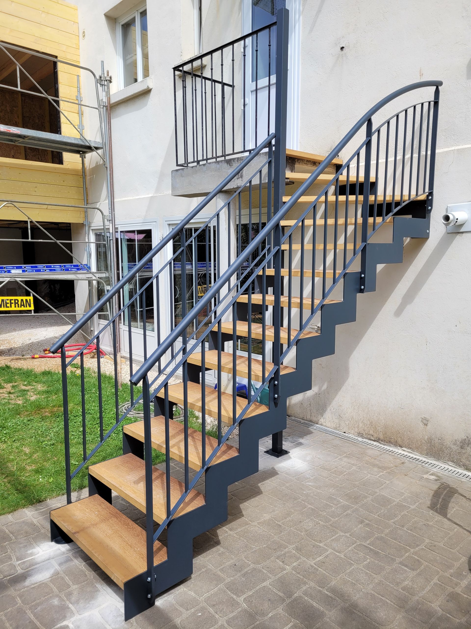 Escalier extérieur en métal avec marches en bois.