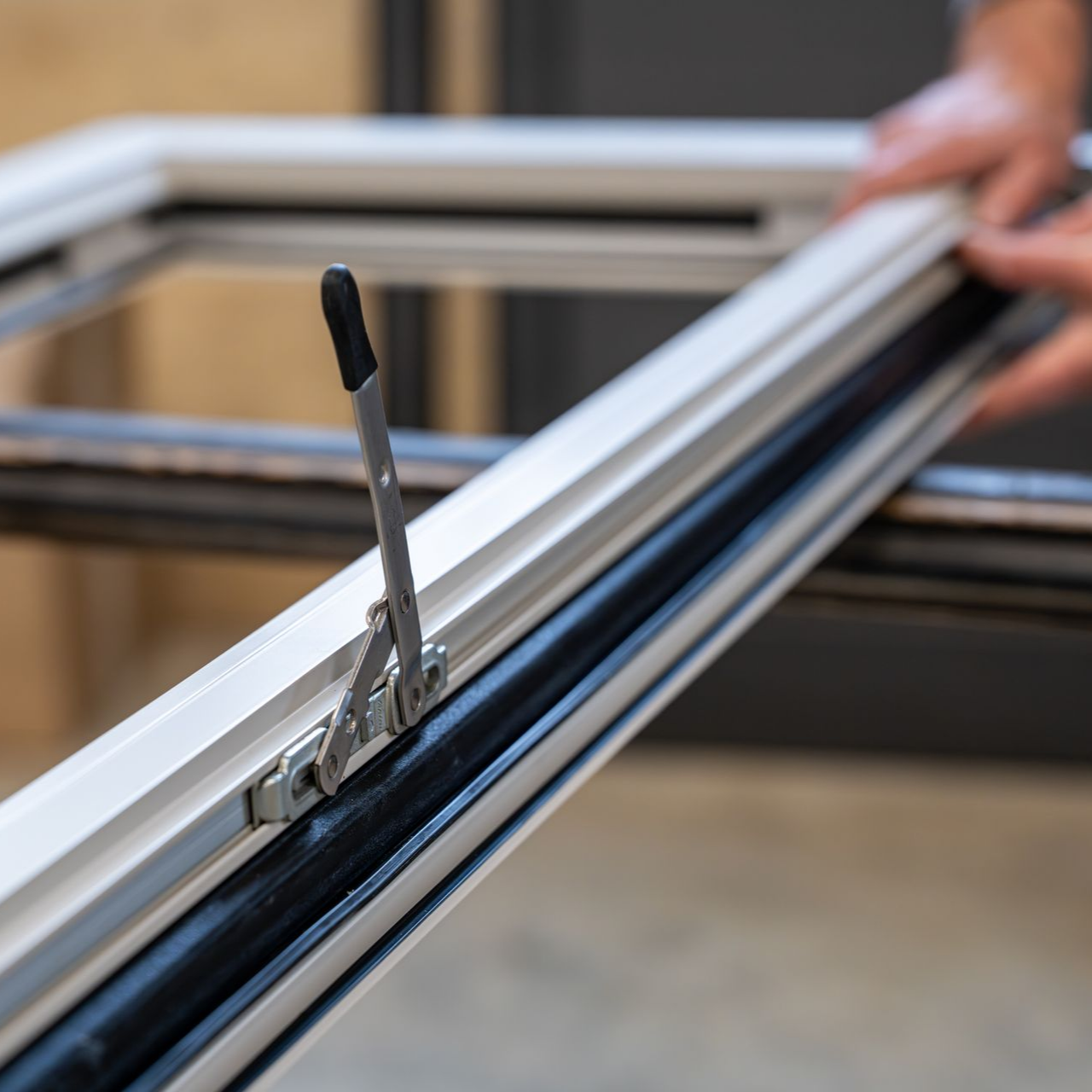 Installation d’un mécanisme de verrouillage sur une fenêtre en aluminium.