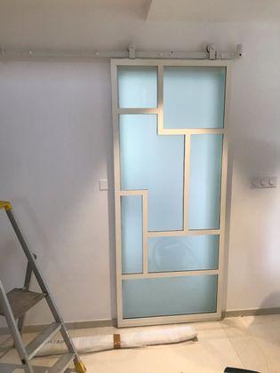 Porte coulissante intérieure en verre dépoli avec un cadre blanc.