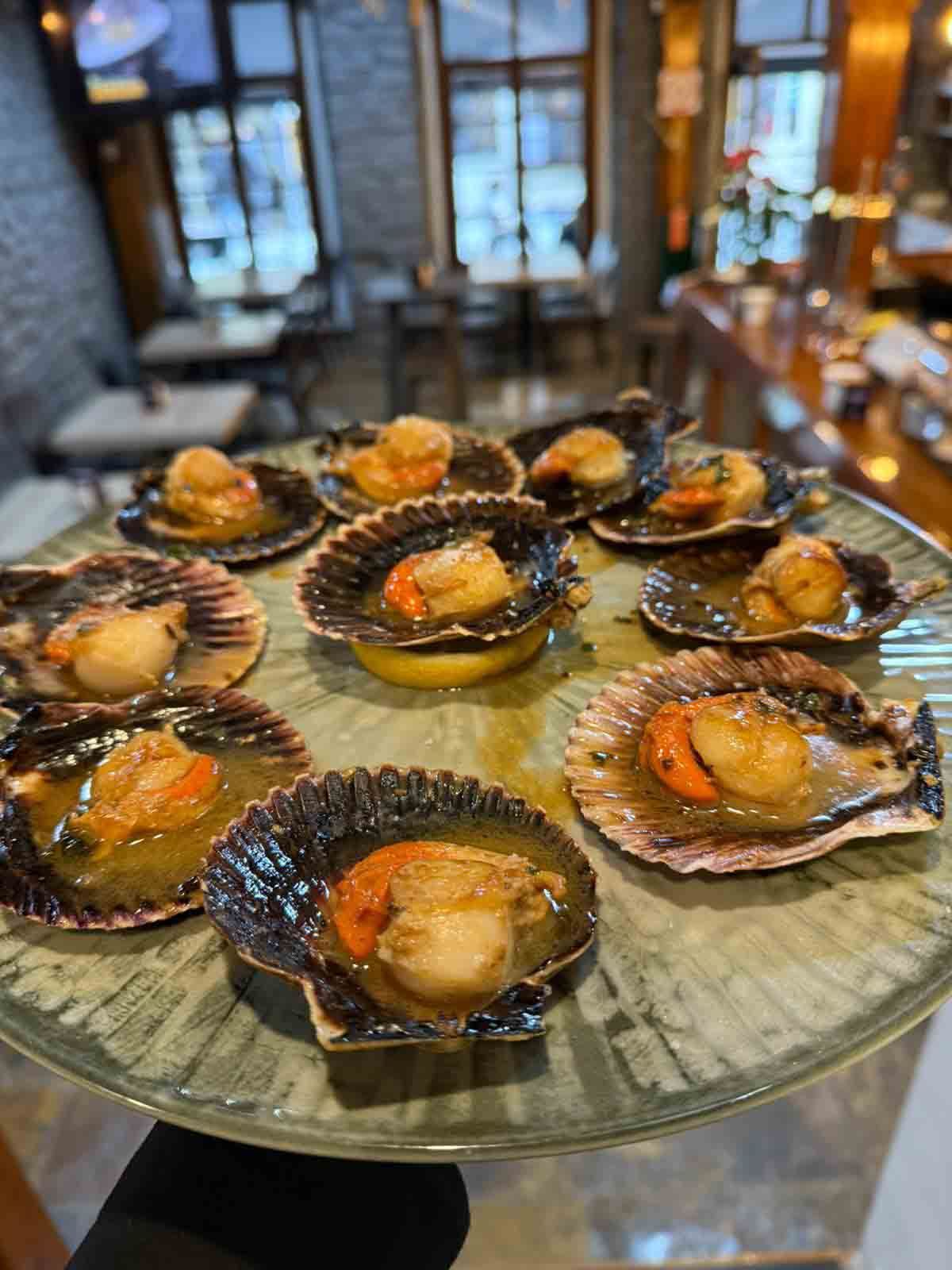 Un plato de vieiras en un plato de cristal en un restaurante.