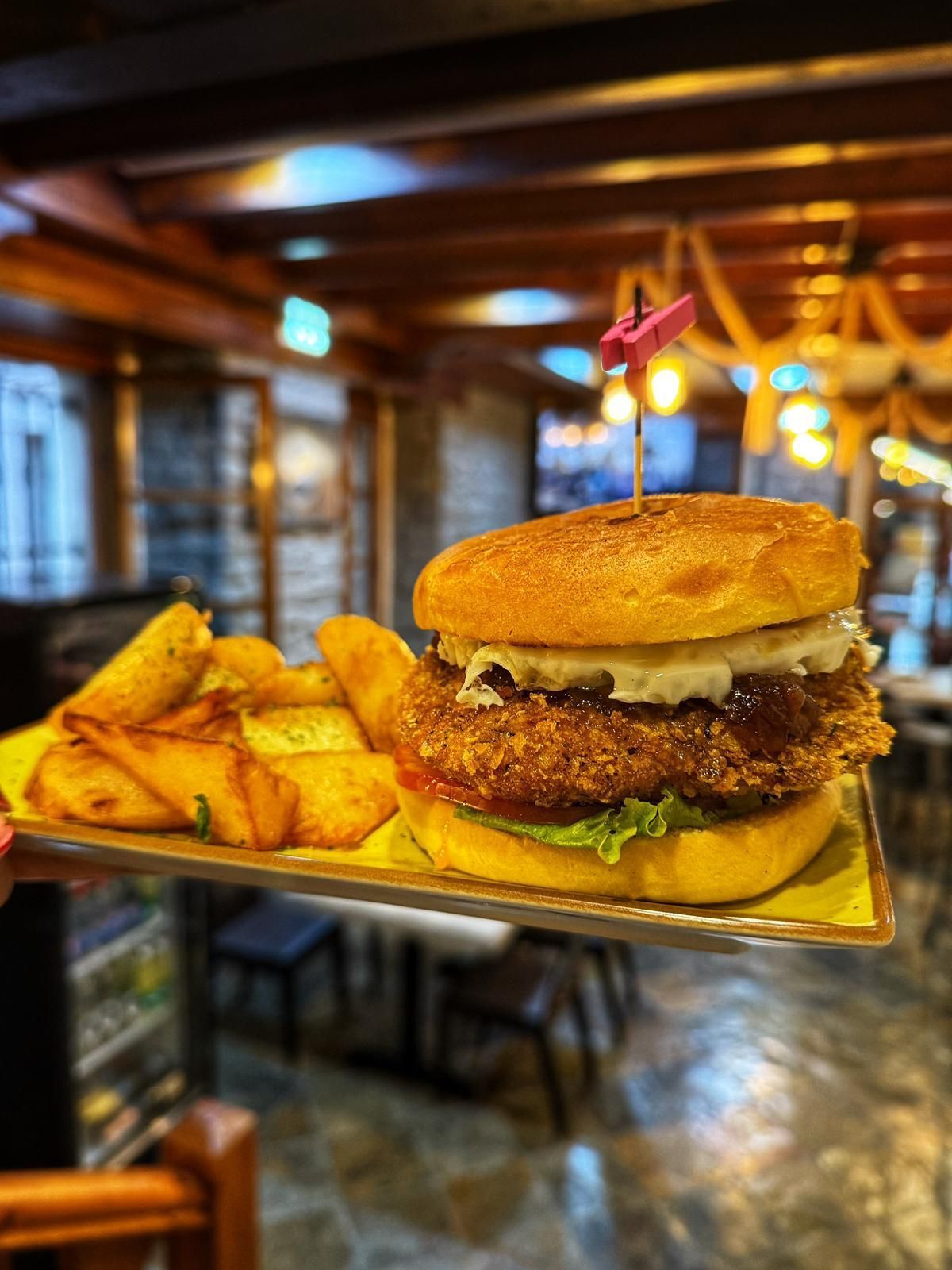 Una hamburguesa y patatas fritas en una bandeja en un restaurante.