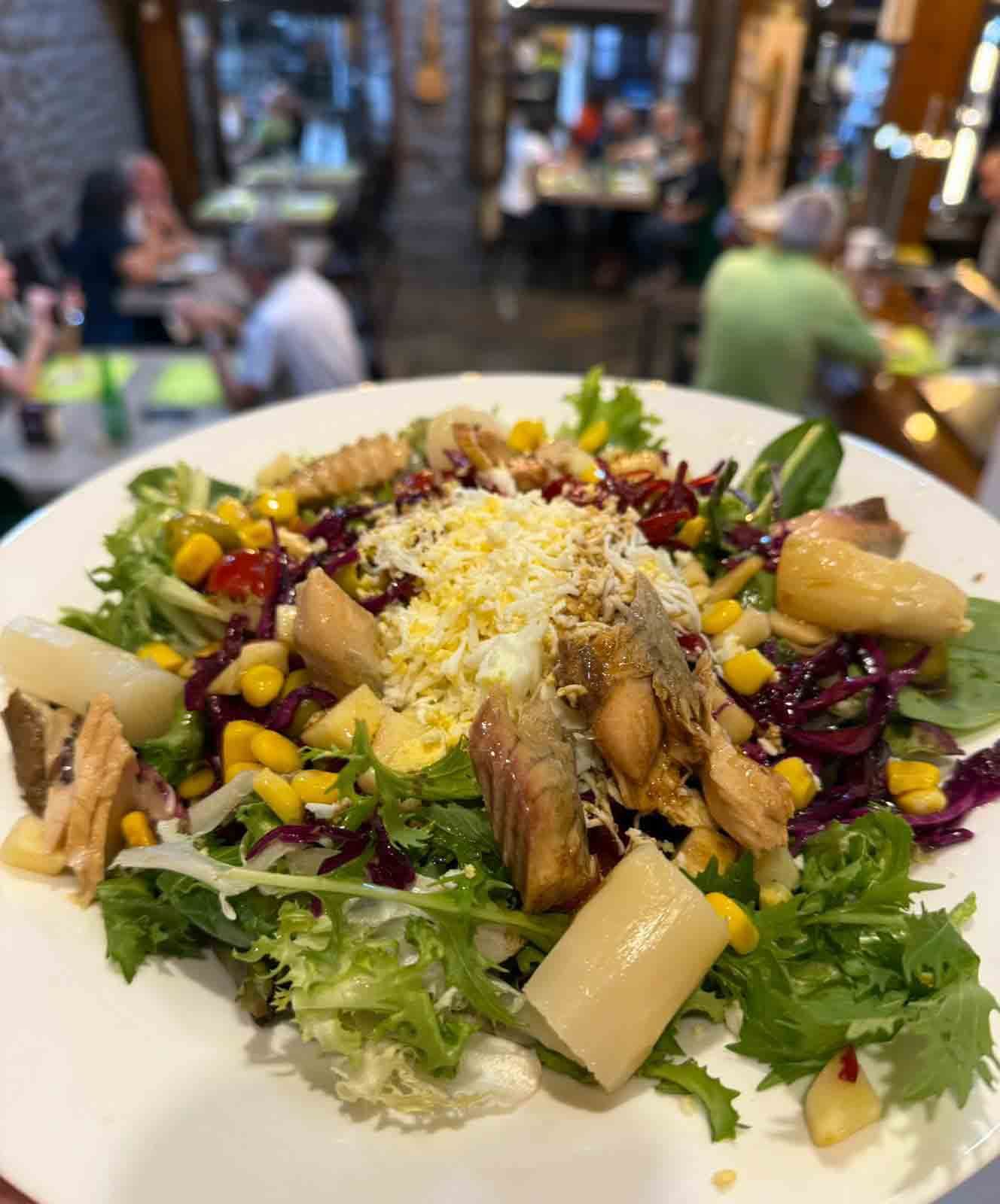 Un primer plano de una ensalada en un plato en un restaurante.