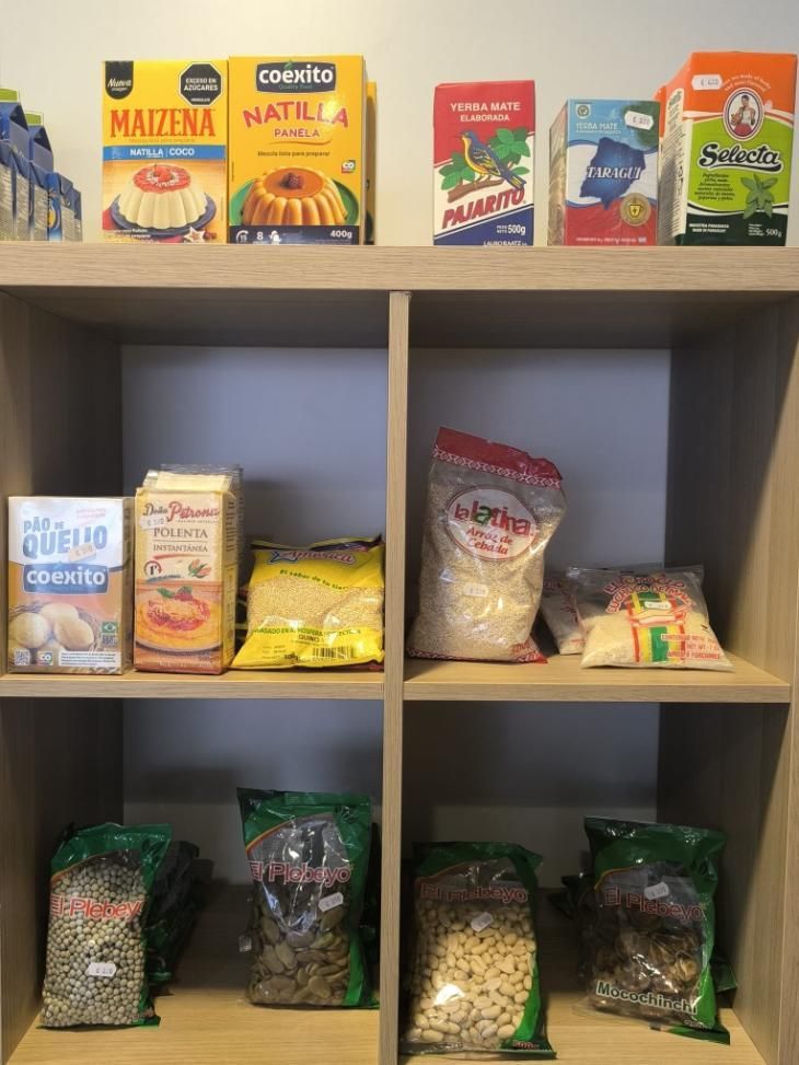 Estante con alimentos envasados: almidón de maíz, mezcla para flan, harina, arroz, frijoles, harina de maíz.