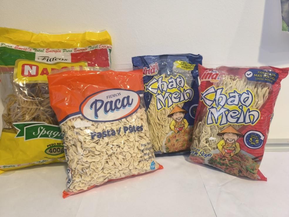 Cuatro paquetes de pasta: espaguetis, pasta y fideos, y dos Chao Mein, de varios colores.