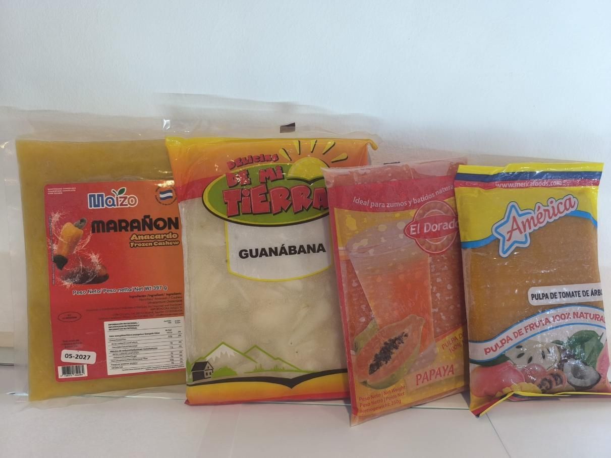 Cuatro bolsas selladas de pulpa de fruta congelada sobre un fondo blanco; los sabores incluyen guayaba y guanábana.