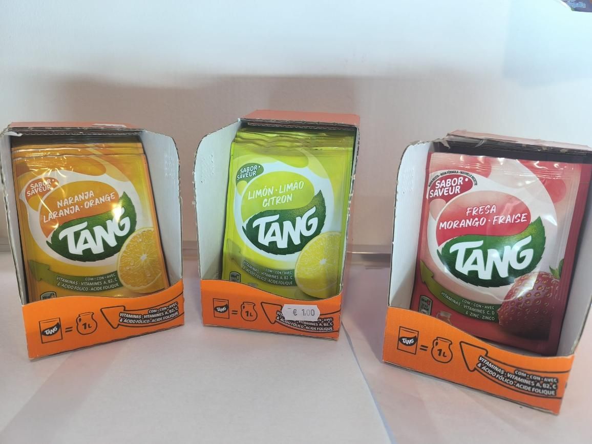 Tres paquetes de mezcla para bebida Tang: naranja, limón y fresa. Cada uno se presenta en una caja.
