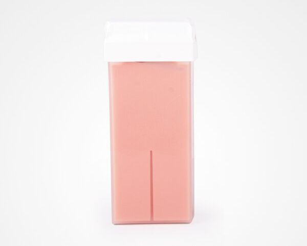 Un rodillo de cera rosa con una tapa blanca sobre un fondo blanco.