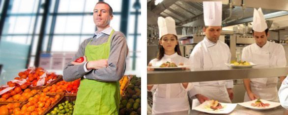 Un hombre con delantal está de pie junto a un grupo de chefs en una cocina.