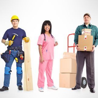 Una mujer con un uniforme rosa está parada entre dos hombres que sostienen cajas.
