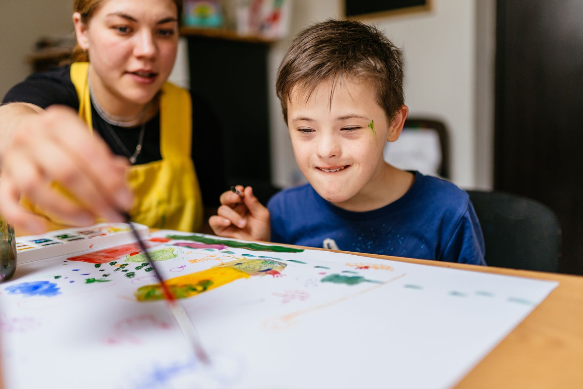Enfant handicapé faisant de la peinture avec sa maman
