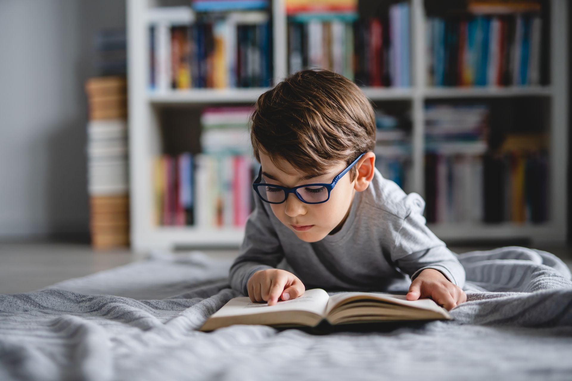 Enfant lisant un livre sur son lit
