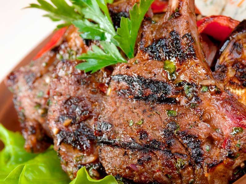 Un primer plano de un plato de comida con carne y verduras sobre una mesa.