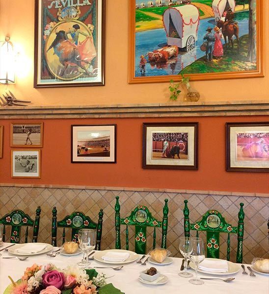 Un comedor con una mesa y sillas y un cuadro en la pared que dice sevilla