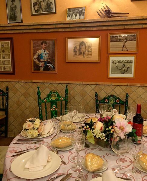 Una mesa con platos, vasos y flores encima.