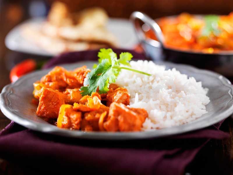 Un plato de comida con arroz y pollo en una mesa.