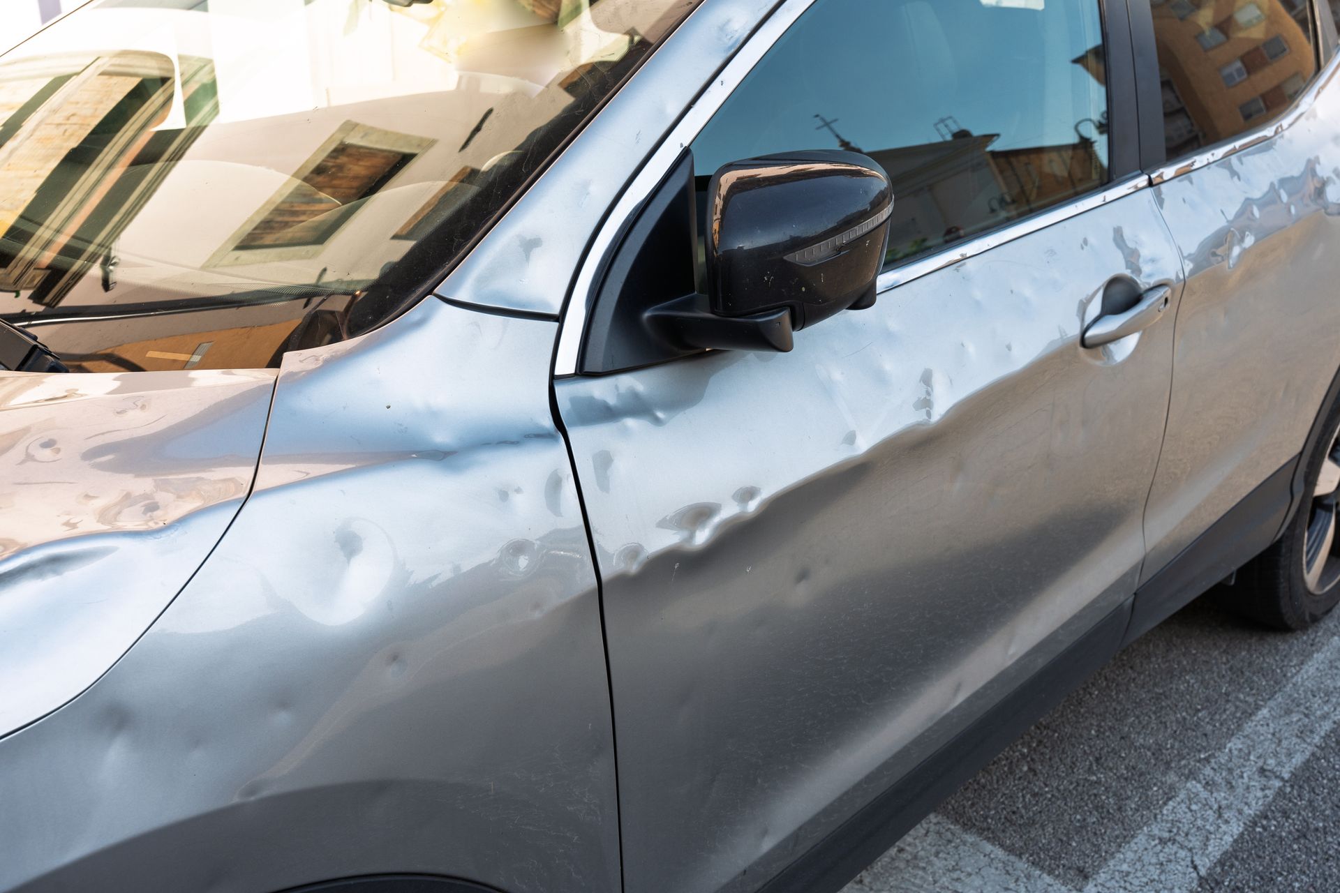 Voiture avec d'importants dégâts causés par la grêle sur le côté