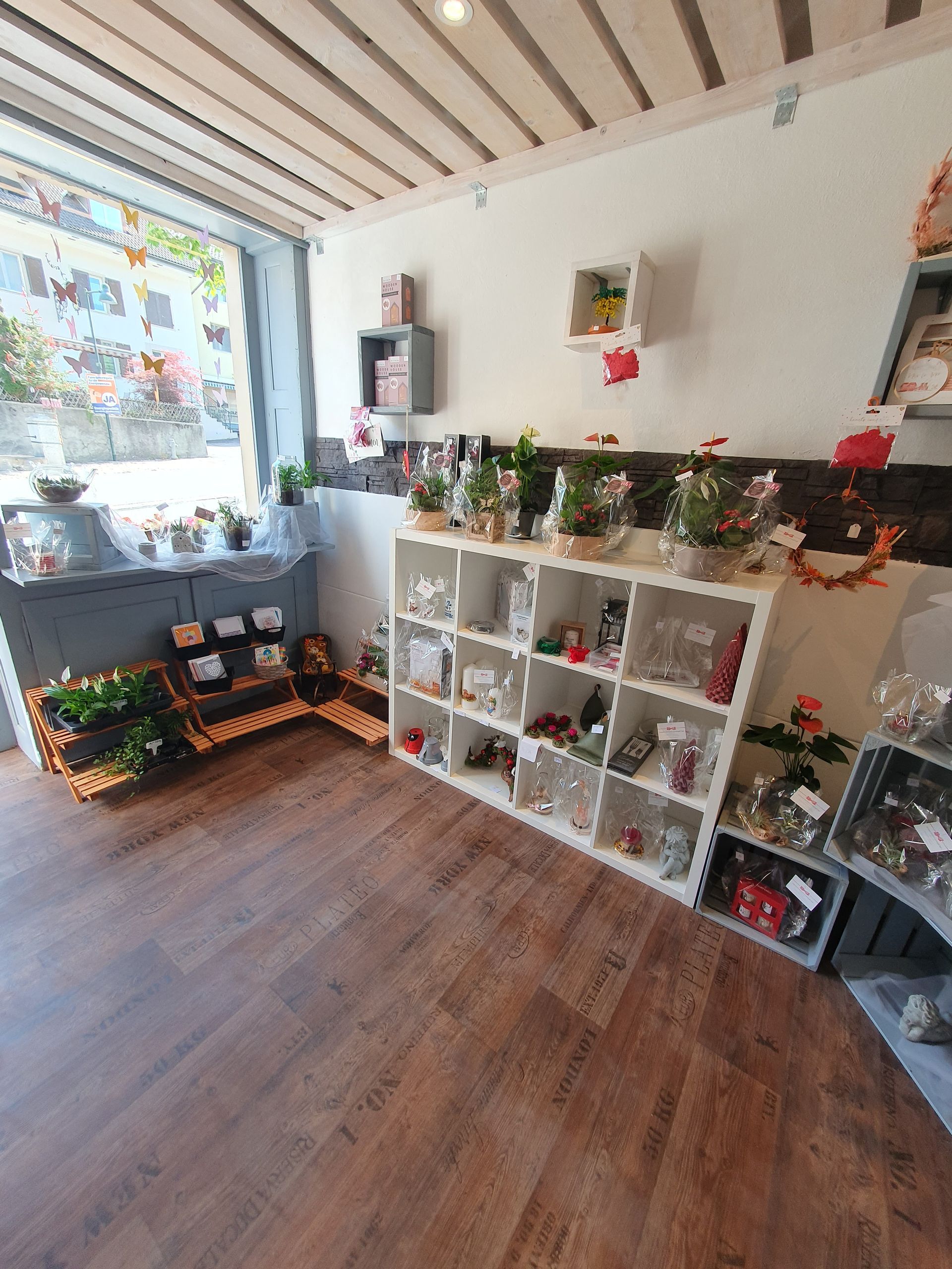 Gemütlich dekoriertes Zimmer mit Holzboden, Fensterbank, weissen Regalfächern und Weihnachtsgirlanden