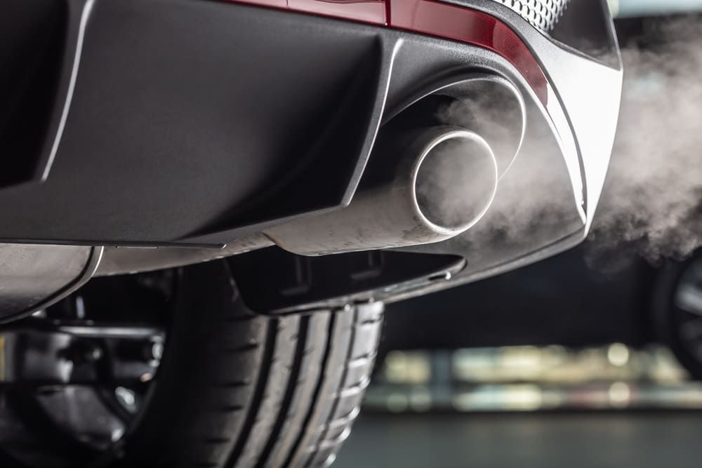 Rauch kommt aus dem Auspuff eines Autos | Gotthelf Garage AG