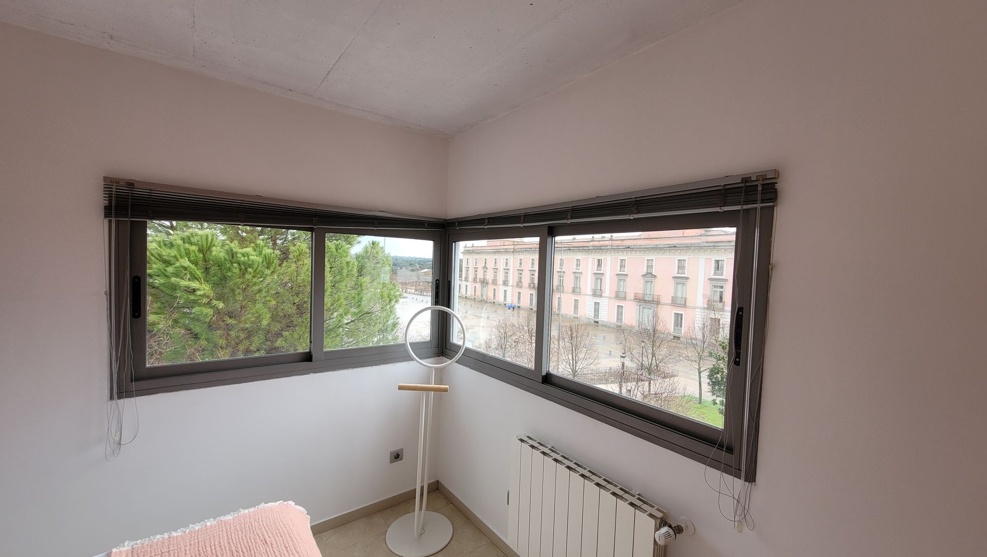 Un dormitorio con una gran ventana y un radiador.