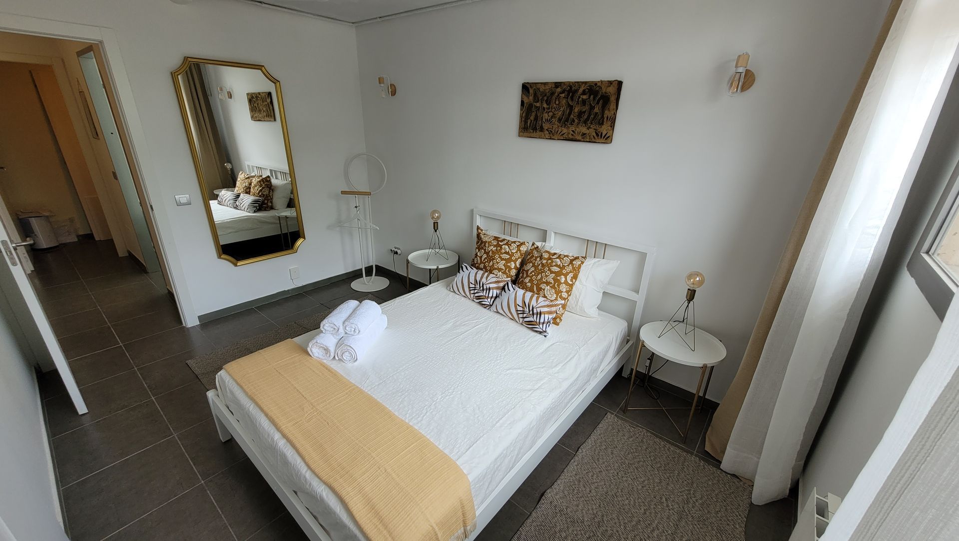 Un dormitorio con una cama grande y un espejo en la pared.