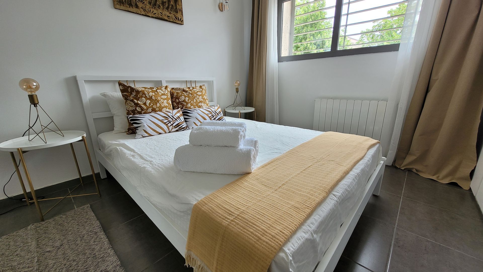 Un dormitorio con una cama, dos mesitas de noche y una ventana.