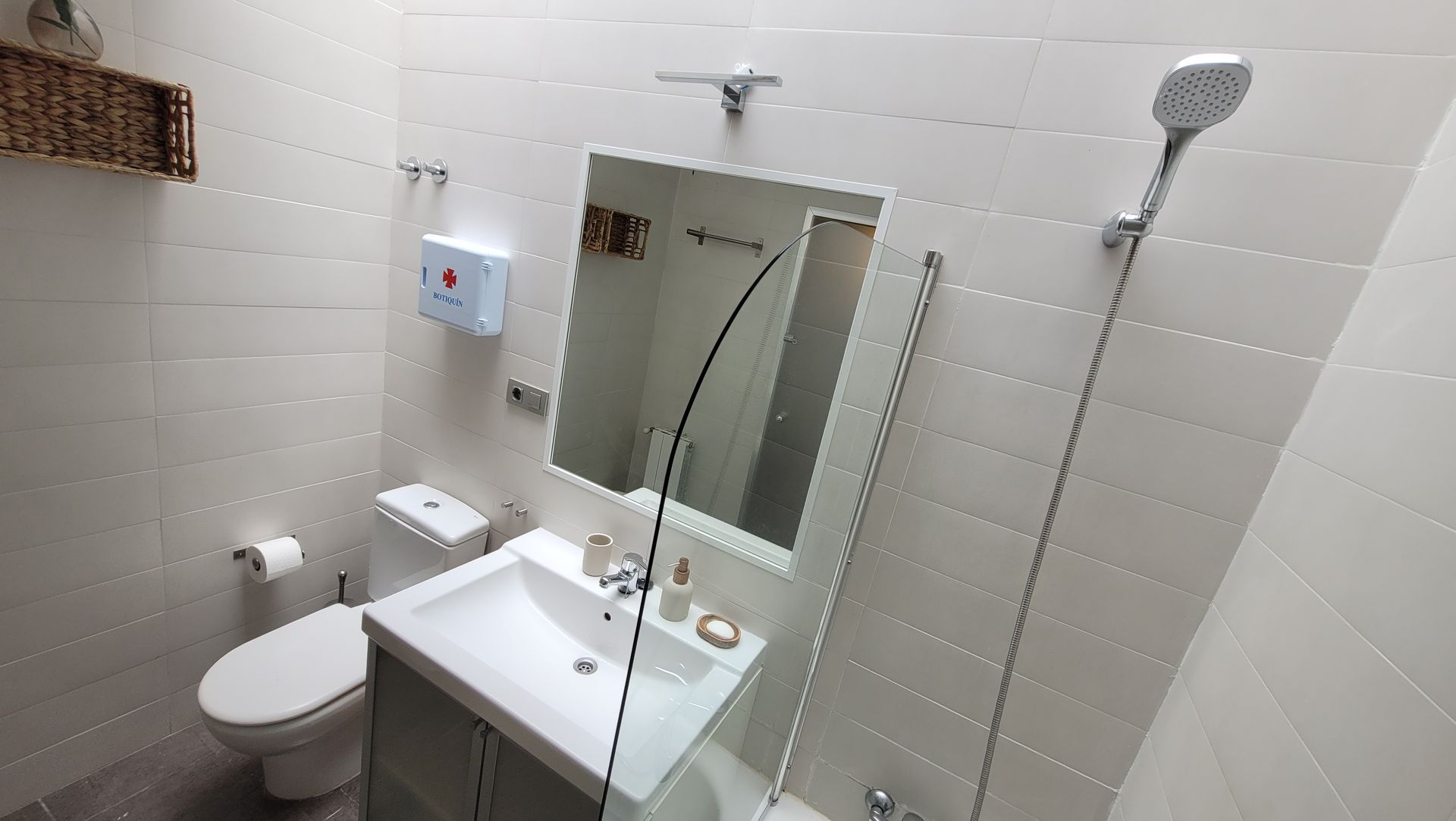 Un baño con lavabo, inodoro, espejo y ducha.