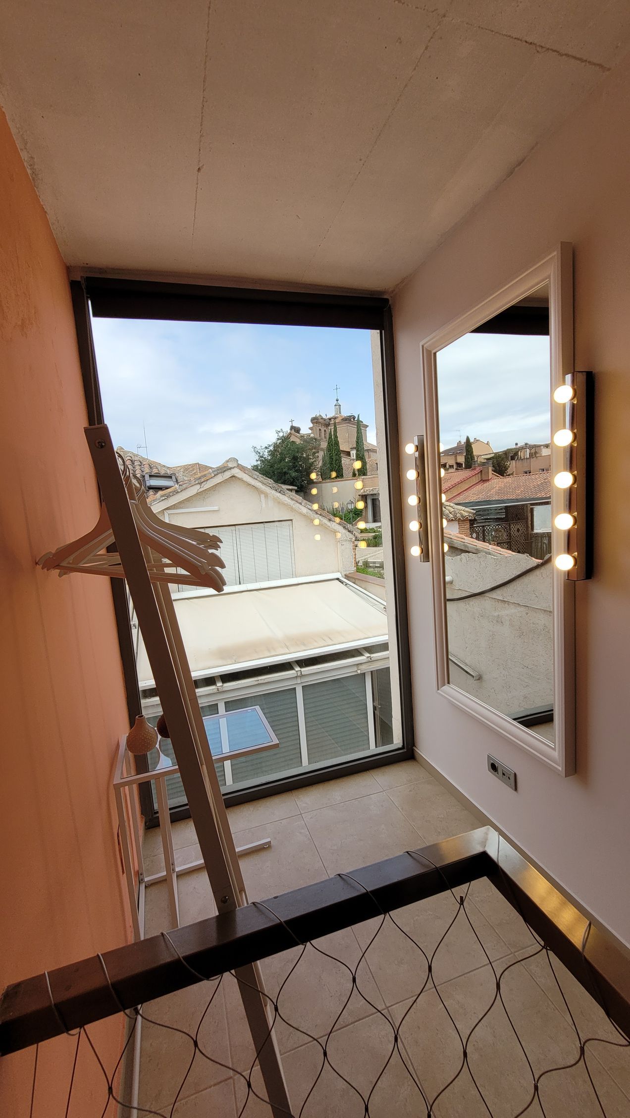 Una habitación con una ventana grande y un espejo en la pared.