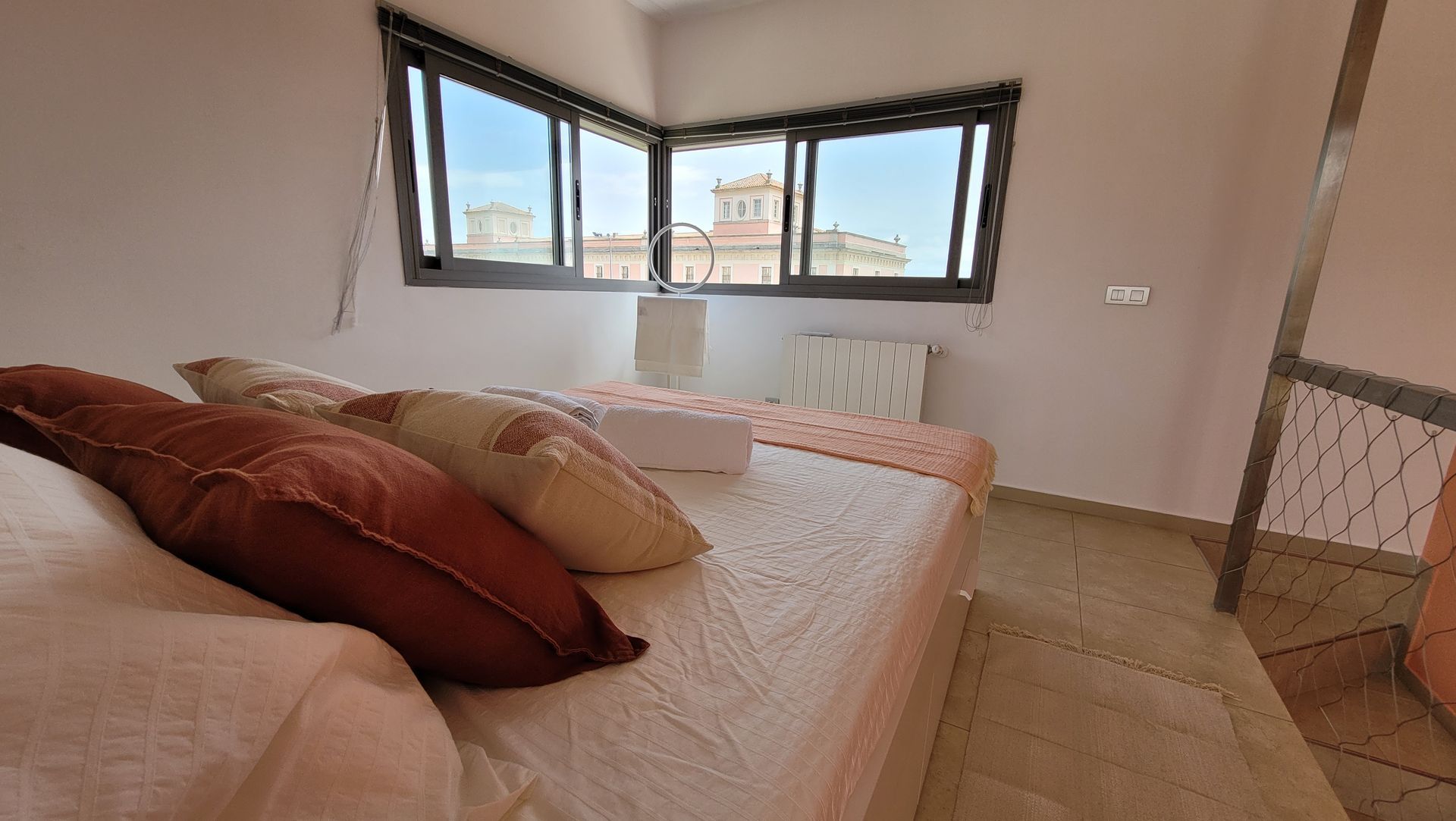 Un dormitorio con una cama, almohadas y una ventana.