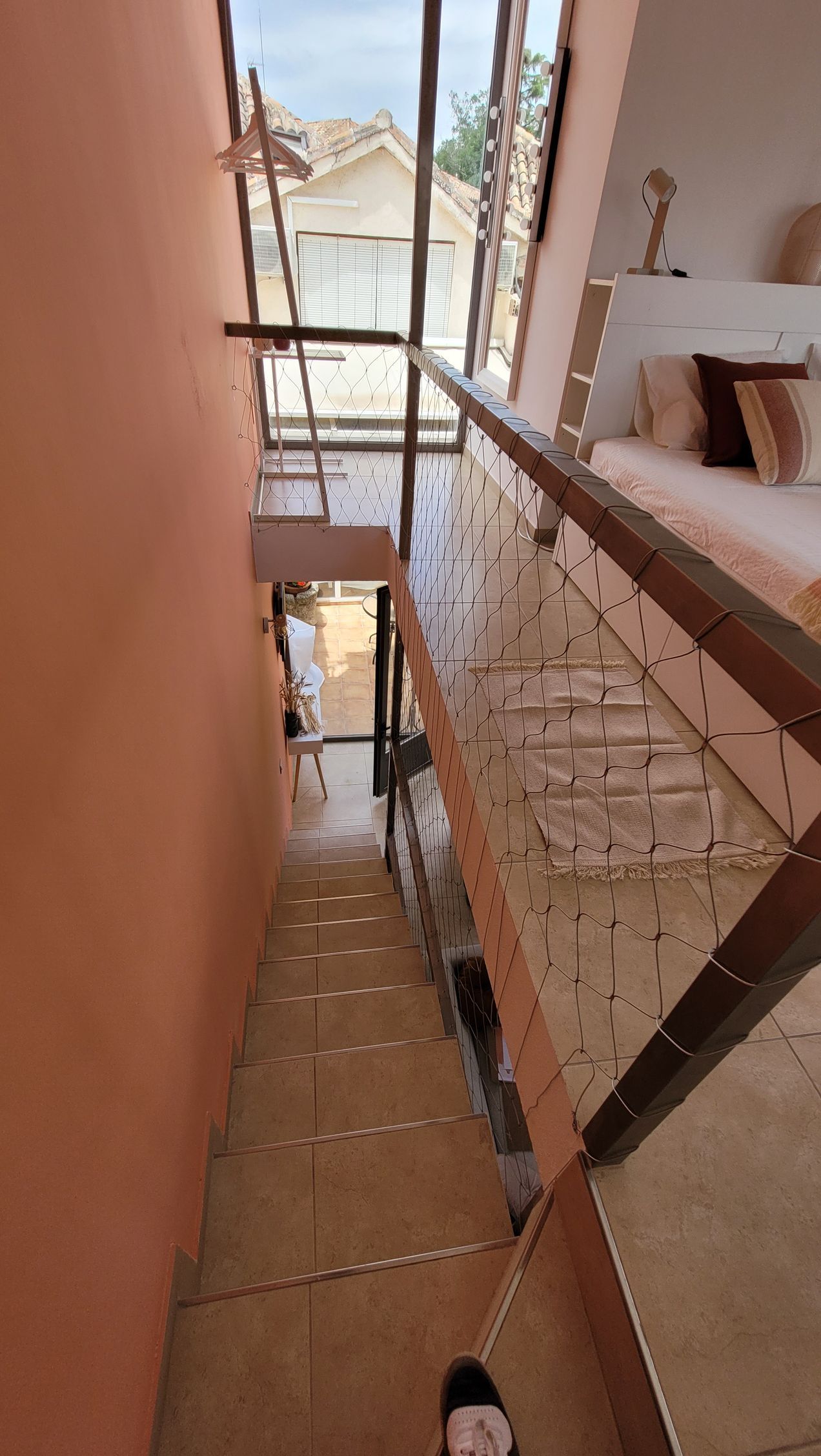 Una persona está bajando un tramo de escaleras en una casa.