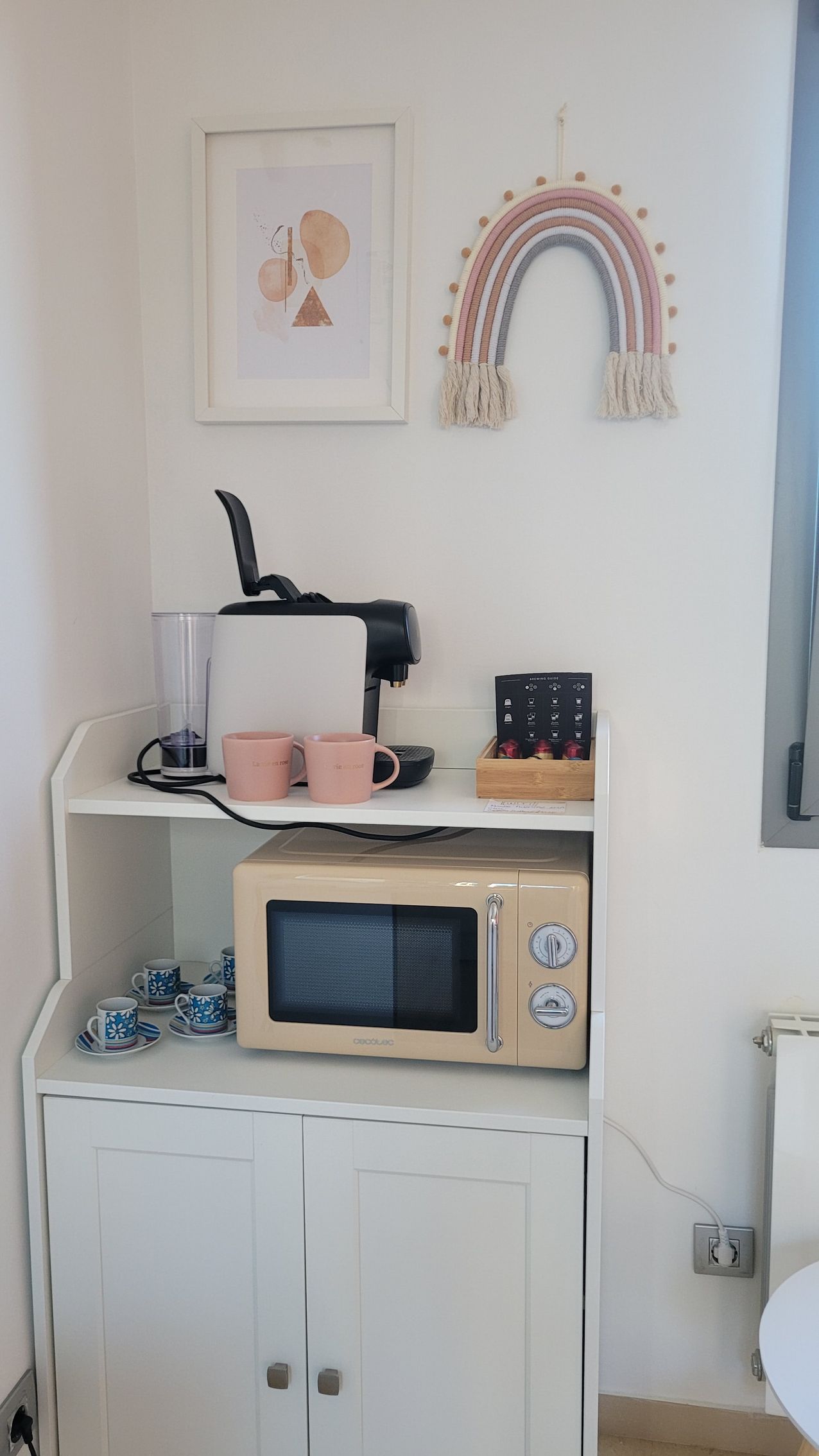 Un horno microondas está colocado encima de un armario blanco.