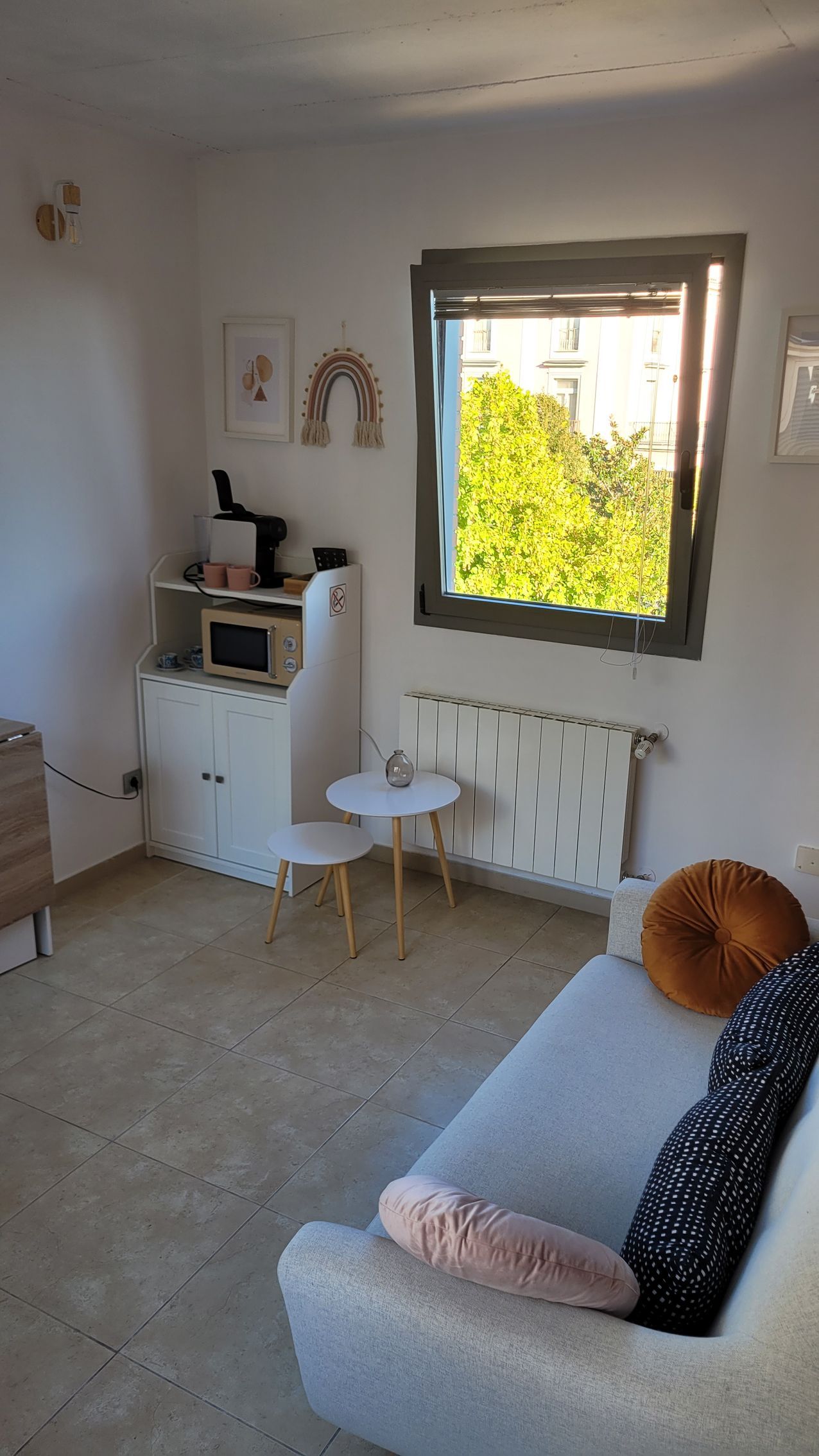 Una sala de estar con sofá, mesa y ventana.