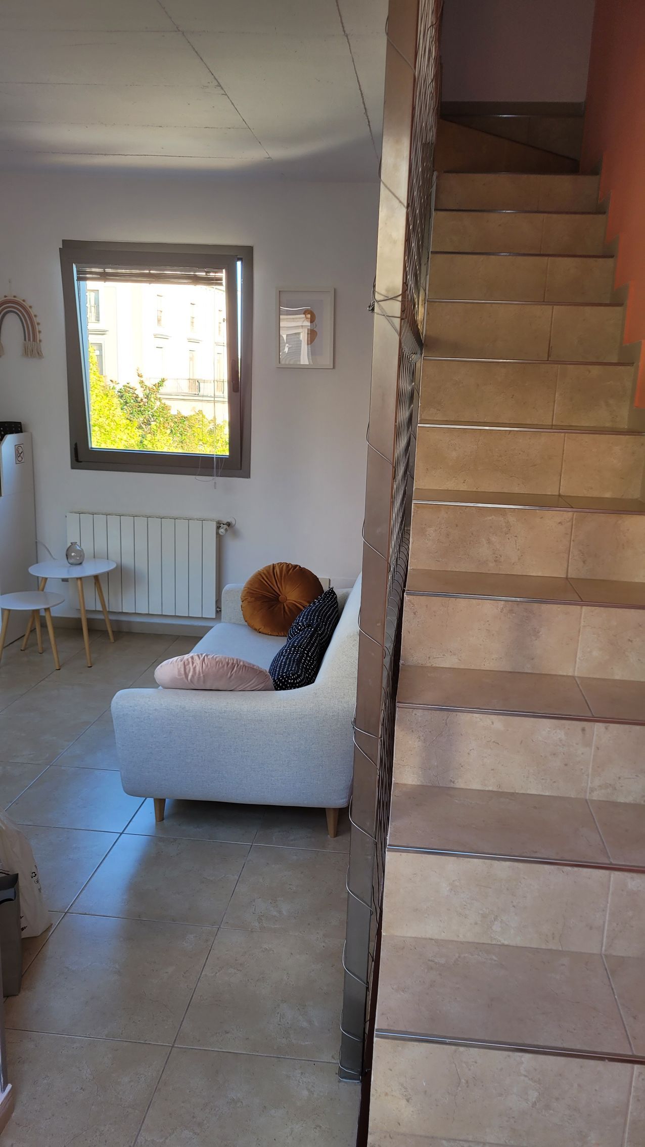 Una sala de estar con un sofá y escaleras que conducen al segundo piso.