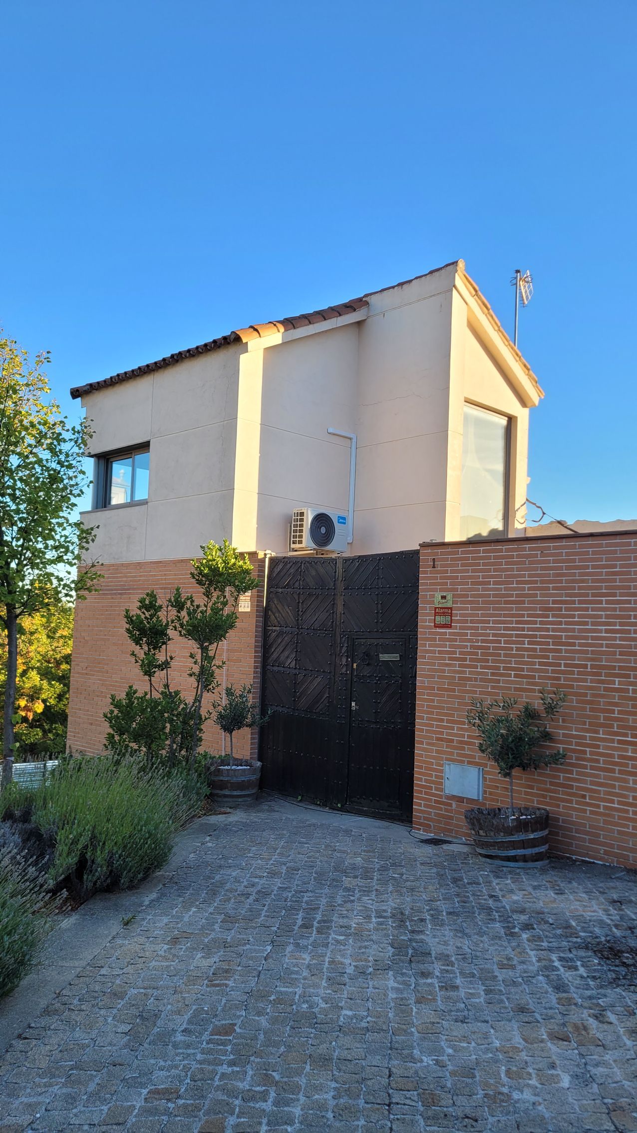 Una casa con una valla y una entrada para coches delante de ella.