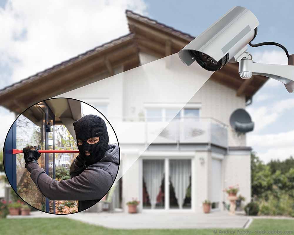 Überwachungskamera auf Haus gerichtet, in das ein Einbrecher einzudringen versucht.