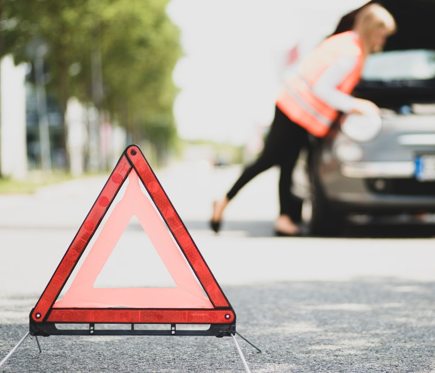 Un triangle de sécurité devant une voiture arrêtée