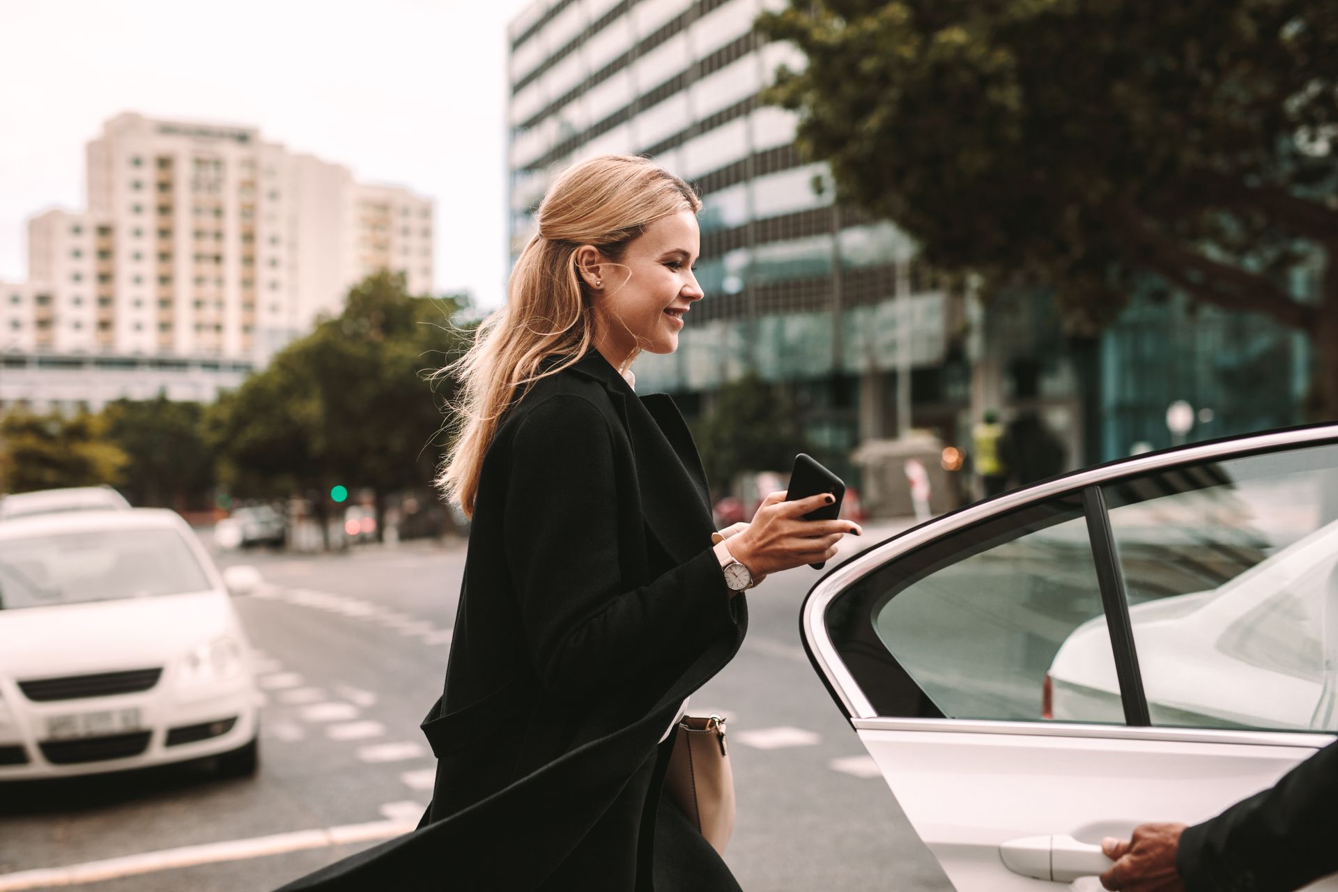 Une femme en manteau noir entrant dans un taxi