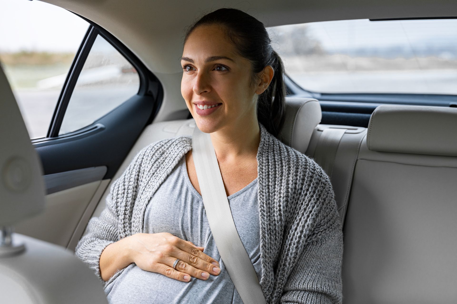 Une femme enceinte à l'arrière d'une voiture