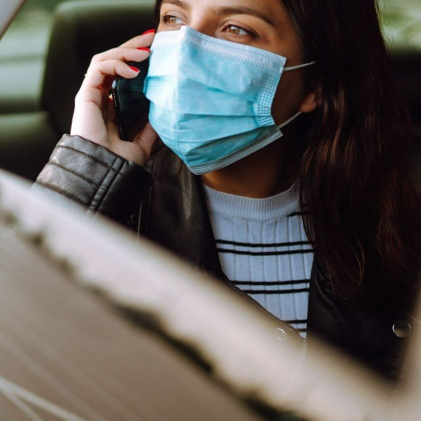 Une femme avec un masque dans un taxi médicalisé