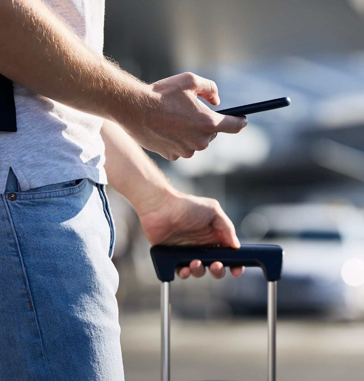 Un homme tenant une valise en train d'appeler un taxi