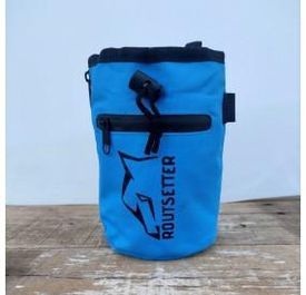 Una bolsa azul con la palabra Routsetter escrita en ella está sobre una mesa de madera.