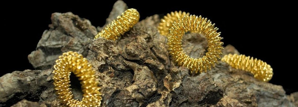 Un primer plano de una pila de anillos de oro sobre una roca.