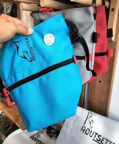 Una persona sostiene una bolsa azul que tiene escrito 