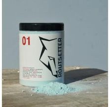 Un frasco de polvo está encima de una mesa de madera.