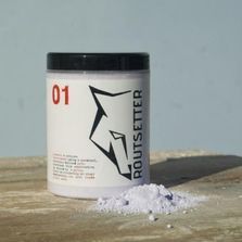 Un frasco de polvo está sobre una mesa de madera al lado de una pila de polvo.