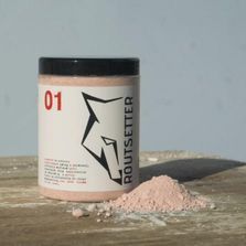 Un frasco de polvo está encima de una mesa de madera.