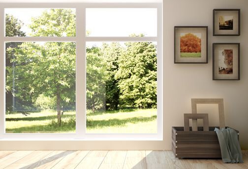 Ein Wohnzimmer mit einem großen Fenster mit Blick auf einen Park.