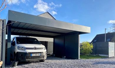 Une camionnette blanche garée sous un abri de voiture moderne à côté d'une maison par une journée ensoleillée.