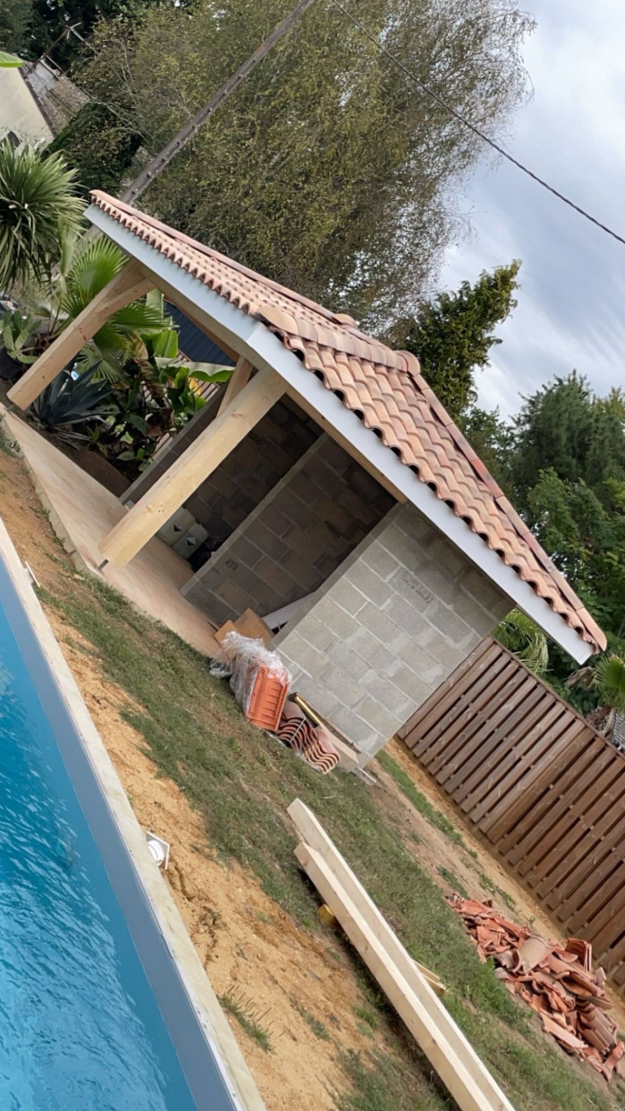 Toiture construite pour une terrasse protégée avec trois murs en parpaings