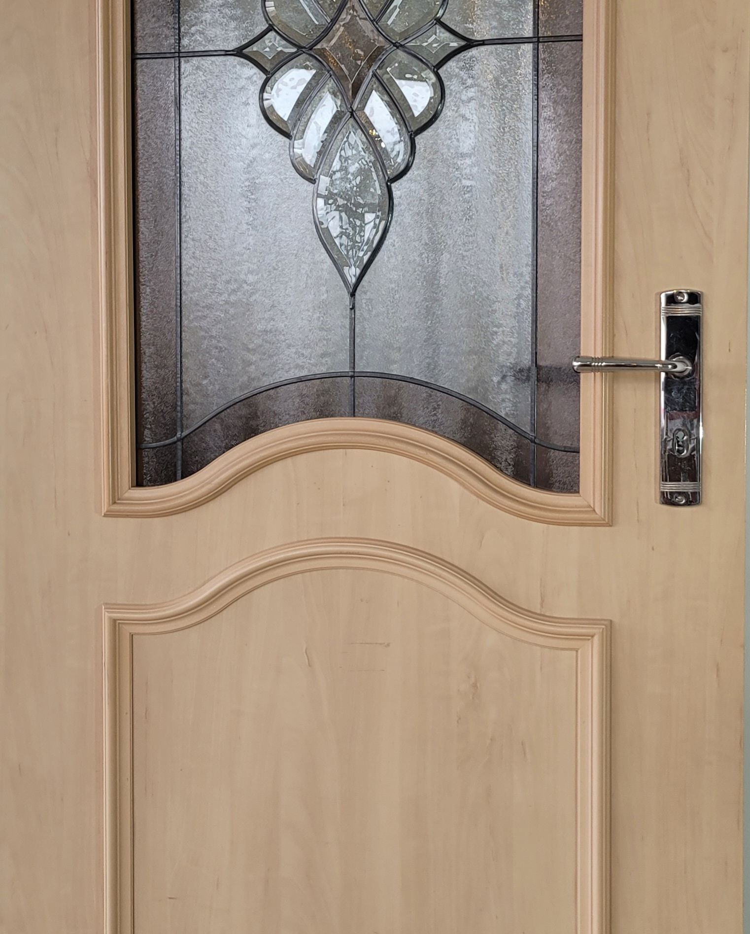 Eine Nahaufnahme einer Tür mit einem Buntglasfenster
